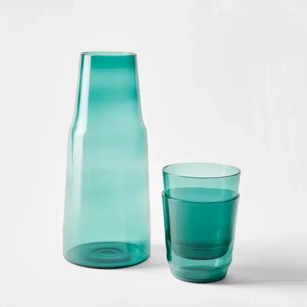 teal glass carafe with two matching drinking glasses stacked