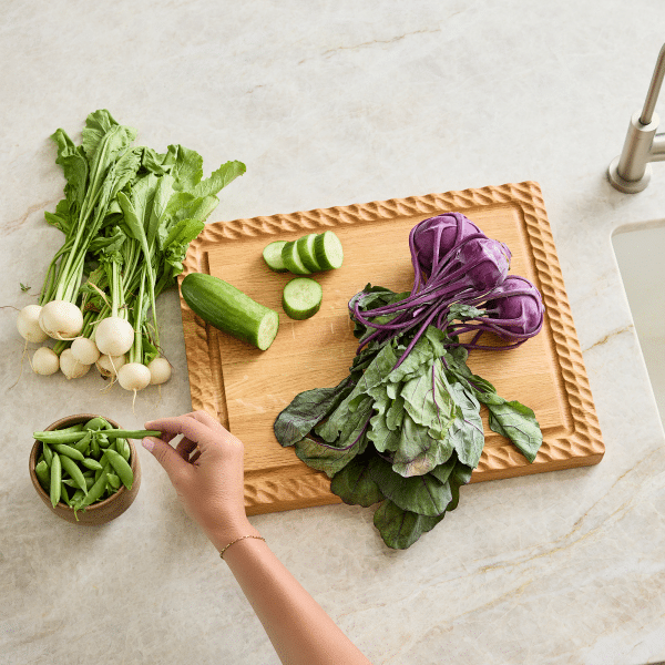 red oak wooden serving board with vegetables and juice groove